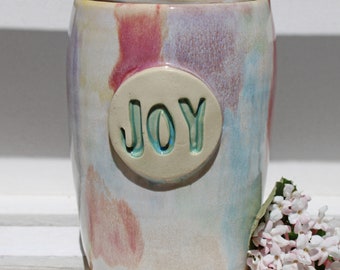 Handcrafted wheel thrown to go ceramic cup, rainbow glaze, joy emblem