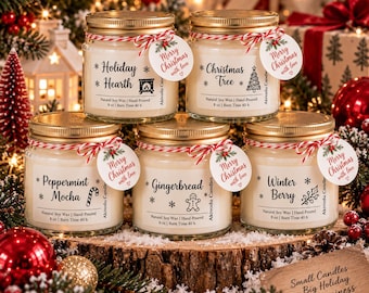 Könnte beinhalten: Fünf Sojawachskerzen in Gläsern mit goldenen Deckeln, weißen Etiketten mit schwarzem Text, rot-weißen Kordelschleifen und runden Anhängern mit der Aufschrift Merry Christmas with love. Die Düfte sind Holiday Hearth, Christmas Tree, Peppermint Mocha, Gingerbread und Winter Berry.