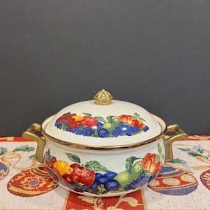 May include: White enamel pot with a gold rim and handles. The pot has a fruit and berry design with red, green, yellow, and blue colors. The pot has a gold knob on the lid.