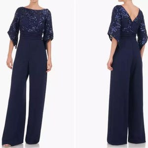 May include: A navy blue jumpsuit with a sequined bodice and wide-leg pants. The top features a boat neckline and three-quarter sleeves. The back view shows a V-neckline. This elegant one-piece outfit is suitable for formal events.