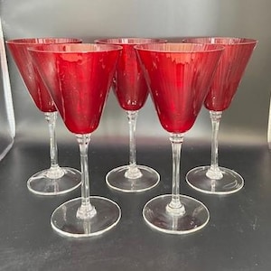 Könnte beinhalten: Satz von fünf Rotweingläsern mit geriffeltem Design. Die Gläser haben klare Stiele und Füße.