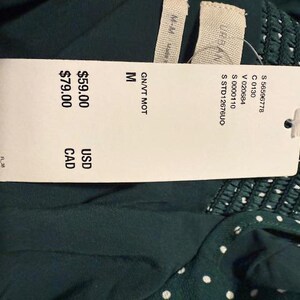 May include: A green and white polka dot dress with a white tag that says "GN/VT MOT M &pound;59.00 GBP &pound;79.00 CAD"