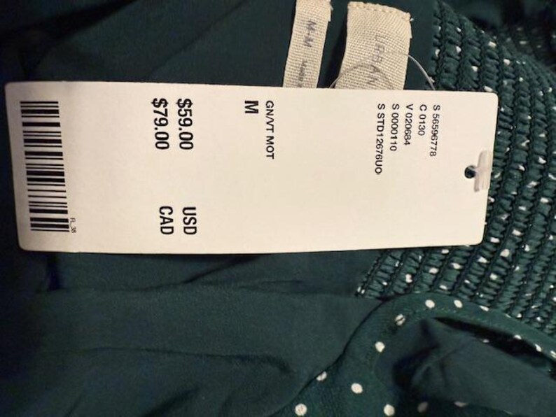 May include: A green and white polka dot dress with a white tag that says "GN/VT MOT M &pound;59.00 GBP &pound;79.00 CAD"