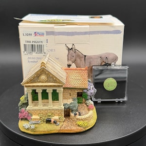 May include: A detailed miniature figurine of a building with a classical facade, green columns, and a red-tiled roof. The figurine is accompanied by a box with the text "THE PIGSTY" and a small coin in a clear case.