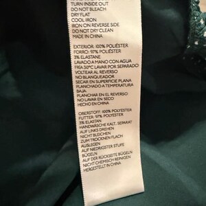 May include: A white care label with black text detailing the care instructions for a garment. The label includes instructions for washing, drying, ironing, and dry cleaning. The label also states that the garment is made in China.
