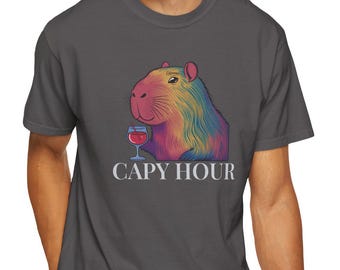 May include: A dark grey t-shirt with a rainbow capybara drinking wine and the text "Capy Hour" printed on the front.