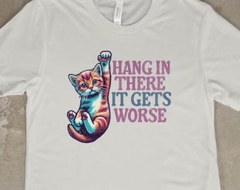 May include: White t-shirt with a graphic of a cartoon cat hanging upside down and the text "Hang in there it gets worse".