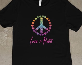 May include: Black t-shirt with a rainbow peace sign made of hearts and the text "Love > Hate" in pink.