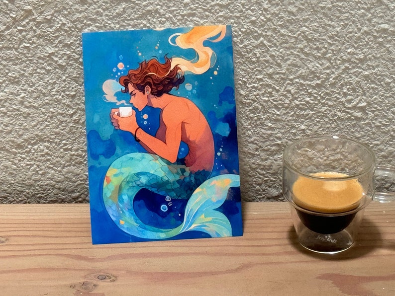 A colorful illustration of a merman drinking from a white cup. He has wavy brown hair, and a shimmering teal and green tail. The overall style is whimsical and dreamy, with a warm color palette contrasting against the cool blue tones of the water.