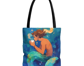 May include: A tote bag featuring a colorful illustration of a mermaid with brown hair and a tail, holding a white mug with steam rising from it. The background is a blue ocean with bubbles.