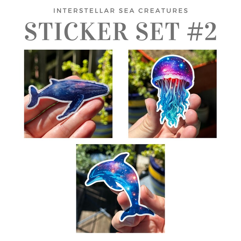 May include: A set of three stickers featuring a whale, a jellyfish, and a dolphin. Each sticker has a galaxy-themed design with blue, purple, and pink colors.