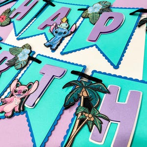 Puede incluir: Una colorida pancarta con la palabra "HAPPY" escrita en banderines turquesas con borde festoneado. Cada bander&iacute;n tiene una letra morada y est&aacute; decorado con personajes de dibujos animados, flores tropicales y palmeras. Una cinta negra une los banderines.