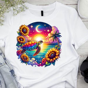 May include: White t-shirt featuring a vibrant graphic of a sea turtle swimming in front of a sunset over the ocean. The design includes sunflowers, a crescent moon, and a palm tree, all in bright colors.
