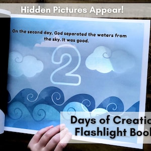 Könnte beinhalten: Offenes Buch mit dem Text "Hidden Pictures Appear!" und "Days of Creation Flashlight Book." Die Seite zeigt einen blauen Himmel mit Wolken, Wellen und der Zahl 2. Der Text lautet: "On the second day, God separated the waters from the sky. It was good."