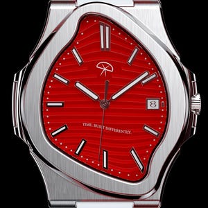 Puede incluir: Un reloj de pulsera de acero inoxidable con una esfera roja brillante. El reloj presenta un diseño único y fluido alrededor de la esfera y una visualización de la fecha a las 3 en punto. La correa del reloj es de acero inoxidable. El texto "TIME BUILT DIFFERENTLY" es visible.