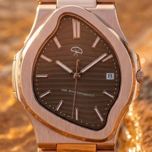 Puede incluir: Un reloj de pulsera de oro rosa con esfera marrón y correa a juego. La esfera del reloj tiene una forma irregular única y muestra la fecha. El reloj está parcialmente sumergido en agua, con el texto "TIME BUILT DIFFERENTLY" visible.