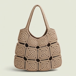 May include: A beige crochet tote bag with a square pattern design. The bag has two handles and a spacious interior. The bag is made of a soft, woven material and is suitable for carrying various items.