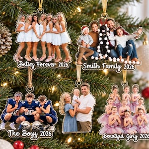 May include: Five custom acrylic Christmas ornaments featuring printed photographs of groups and families, each with white cursive text including 'Besties Forever 2026', 'Smith Family 2026', 'The Boys 2026', and 'Beautiful Girly 2026', all hanging from gold ribbons.