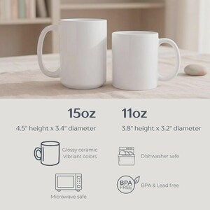 Op de afbeelding: Twee witte keramische mokken, &eacute;&eacute;n van 15 oz en &eacute;&eacute;n van 11 oz, met gebogen handvatten. De grotere mok is 11,4 cm hoog met een diameter van 8,6 cm. De kleinere mok is 9,7 cm hoog met een diameter van 8,1 cm. Kenmerken: glanzend keramiek, levendige kleuren, vaatwasser- en magnetronbestendig, BPA- en loodvrij.