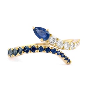 May include: A gold ring with a pear-shaped blue sapphire and a row of smaller sapphires on one side and a row of diamonds on the other side.