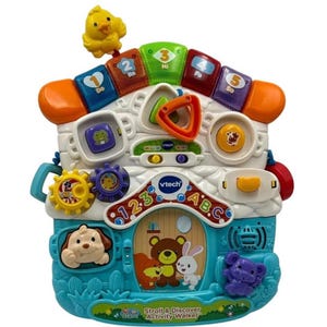 May include: A VTech Sit-to-Stand Activity Walker toy in the shape of a house. It features musical notes, animal figures, and interactive buttons. A yellow chick sits on top. The text "Sit Stand Stroll & Discover Activity Walker" is visible.