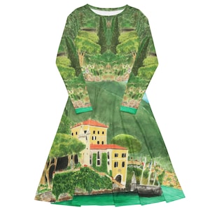Può includere: Un abito a maniche lunghe con una stampa all-over di un paesaggio costiero. Il design raffigura edifici gialli con tetti arancioni immersi tra alberi e colline verdi, con uno specchio d'acqua sul fondo. L'abito ha uno scollo rotondo.