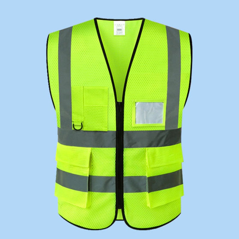 May include: A bright yellow safety vest with reflective strips and multiple pockets. The vest has a zipper closure and a name tag holder.