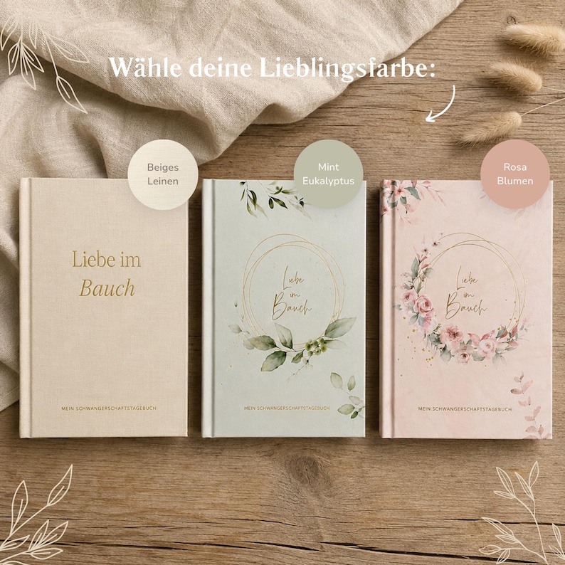 May include: Three hardcover pregnancy journals titled Liebe im Bauch. The left is beige linen, the center is mint green with eucalyptus leaves, and the right is pink with floral wreaths. Each book features gold text and a subtitle.
