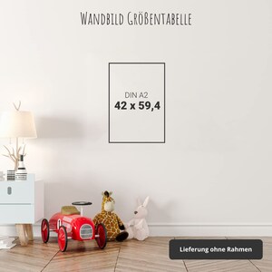 May include: A white wall with a black frame displaying the text "DIN A2 42 x 59,4" and the text "WANDBILD GR&Ouml;&szlig;ENTABELLE" at the top.  A red toy car, a giraffe stuffed animal, and a white bunny stuffed animal are on the floor in front of the wall. The text "Lieferung ohne Rahmen" is at the bottom of the image.