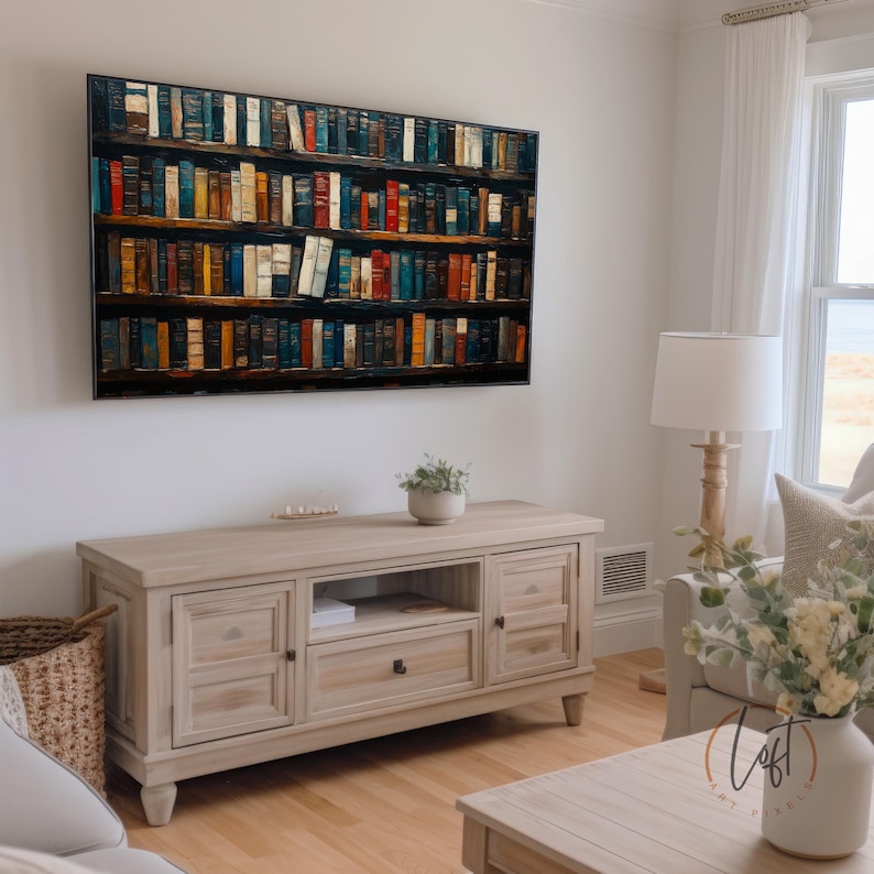 May include: A rectangular television screen displays a digital image of a multi-tiered wooden bookshelf filled with numerous colorful books. The screen is mounted on a plain wall above a light-toned wooden media console with two cabinets and a central drawer.