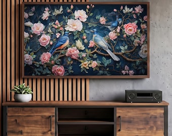 May include: A rectangular wall art print featuring two blue birds perched on branches amidst blooming pink and white flowers against a dark navy background, displayed in a wooden frame above a wooden media console.