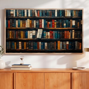 May include: A rectangular wall art print featuring a detailed illustration of four wooden shelves densely packed with numerous hardcover books in various colors including blue, red, yellow, brown, and white, all displayed in a light wood frame.
