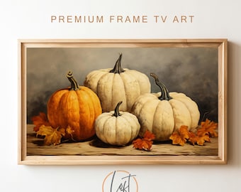 May include: A framed painting of four pumpkins on a wooden table with autumn leaves. The pumpkins are white and orange. The background is a light gray.