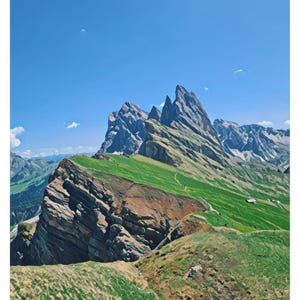 Puede incluir: Una vista panorámica de la cordillera de Seceda en los Dolomitas, Italia. La imagen muestra un pico de montaña rocoso con hierba verde y un camino sinuoso que lleva a la cima. El cielo es azul brillante con algunas nubes blancas.