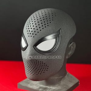May include: A black Spider-Man mask with white mesh eye coverings and a perforated mouth area. The mask is displayed on a gray head form. The text "@PABLOPROPS" is visible on the mask.