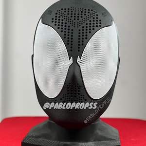 Op de afbeelding: Zwart-witte 3D-geprinte Spider-Man-maskerluidspreker met een zwarte basis. Het masker heeft een wit gaas over de ogen en een zwart gaas over de rest van het masker. De basis heeft de tekst "@PABLOPROPSSS" erop.