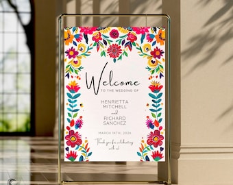 May include: A colorful welcome sign with a floral border in a traditional Mexican style. The sign reads "Welcome to the wedding of Henrietta Mitchell and Richard Sanchez, March 14th, 2026. Thank you for celebrating with us!"