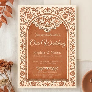 May include: Wedding invitation with a cream and terracotta color scheme. The invitation features ornate floral and scroll designs, with the text "Our Wedding" and details for Sophia & Mateo. Includes RSVP information.