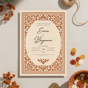Puede incluir: Una invitación de boda con fondo crema y borde floral marrón decorativo. La invitación incluye los nombres "Emma & Benjamin", la fecha "18 de septiembre de 2020" y la dirección "747 Front St. San Francisco, CA 94111, USA".