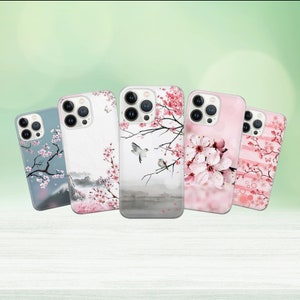 May include: Five different iPhone cases with floral designs. The cases feature pink cherry blossoms and birds on a white background. The cases are all clear and show the phone's camera lens.