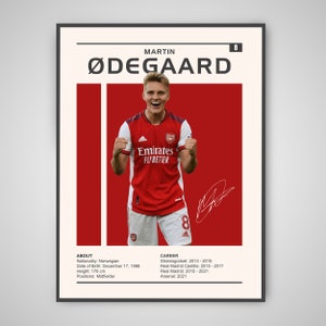 May include: A red and white soccer jersey with the text "Emirates Fly Better" on the front. The jersey has the number 8 on the front and back. The player is wearing the jersey and has his arms raised in celebration. The player's name is Martin Ødegaard. The background is red.