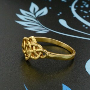 May include: A gold ring featuring a Celtic knot design. The ring is simple and elegant, and would make a great gift for someone special.