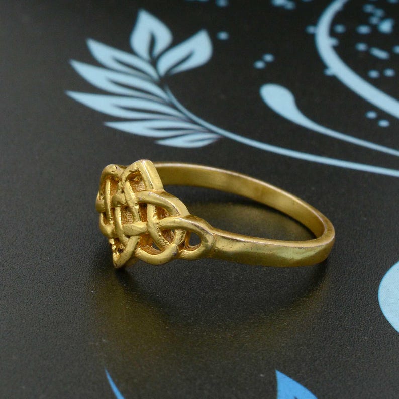 May include: A gold ring featuring a Celtic knot design. The ring is simple and elegant, and would make a great gift for someone special.