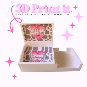 May include: A white 3D printed business card holder with an open lid, featuring a cow print interior and a stack of cards inside. The text 3D Print it. THIS IS A STL FILE DOWNLOAD is visible above the holder, along with pink star graphics.