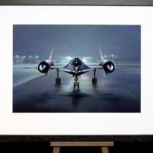 Puede incluir: Un avión de combate furtivo negro en una pista de aterrizaje de noche. El avión está de frente a la cámara con el tren de aterrizaje bajado. La pista está mojada y hay luces en el fondo.