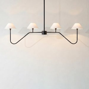 May include: A modern black metal chandelier with four white lampshades. The lampshades are cone-shaped and emit a soft light. The fixture has a minimalist design, suitable for various interior styles.