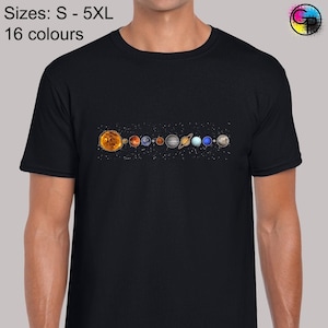 May include: A black t-shirt featuring a graphic of the solar system, including the sun and all the planets. The text "Sizes: S - 5XL 16 colours" is printed at the top of the shirt.