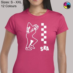 May include: Pink t-shirt featuring a white silhouette of a person dancing and the word "SKA" printed on it.