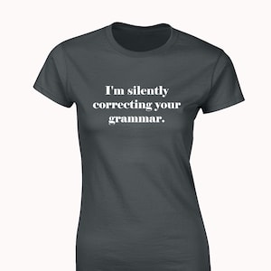 May include: A dark grey t-shirt with the text "I'm silently correcting your grammar." printed in white.
