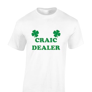 May include: White t-shirt with green shamrock designs and the text "CRAIC DEALER" printed on the front.